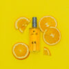 Orange slices laid around an AM After Shave 3.3oz bottle