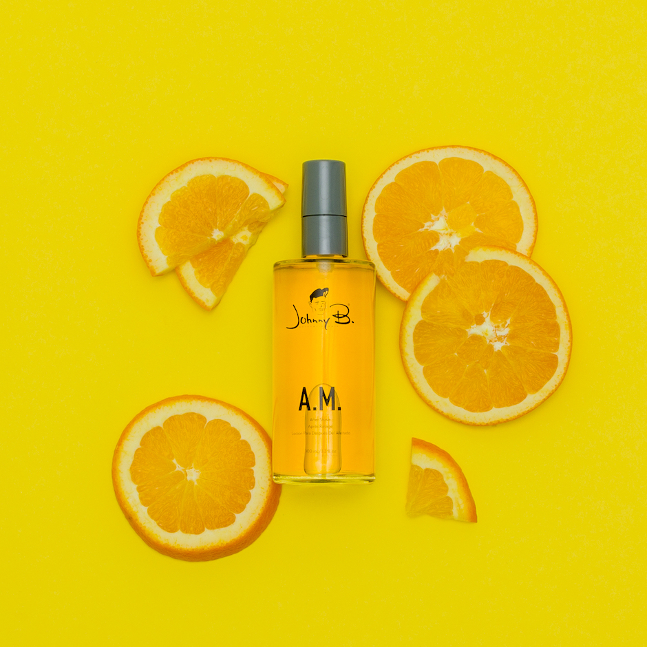 Orange slices laid around an AM After Shave 3.3oz bottle