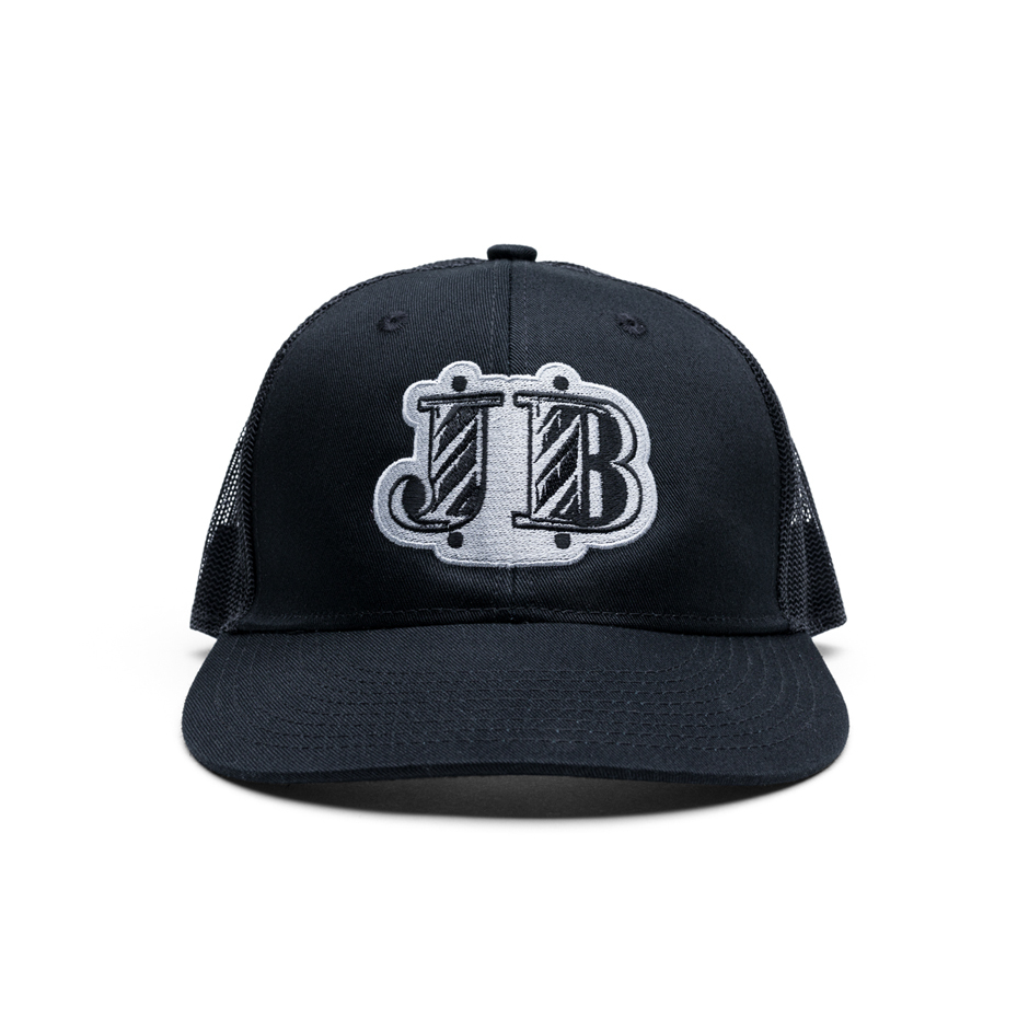 Johnny B. dark gray trucker hat. Johnny B. logo patchwork is stitched in white.