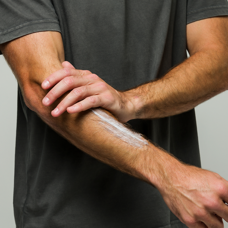 Man using Utility Cream to moisturize arm